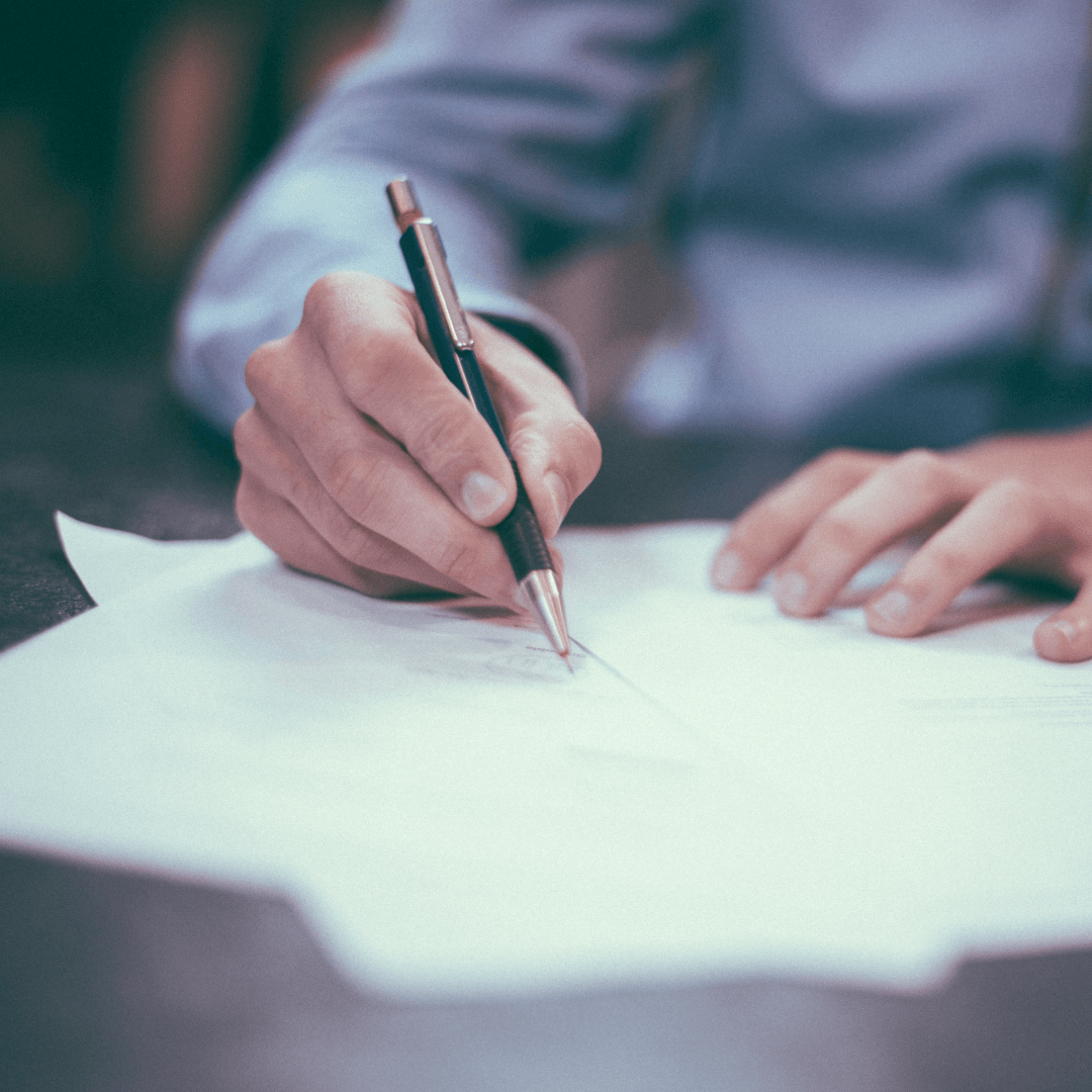 man writing on paper